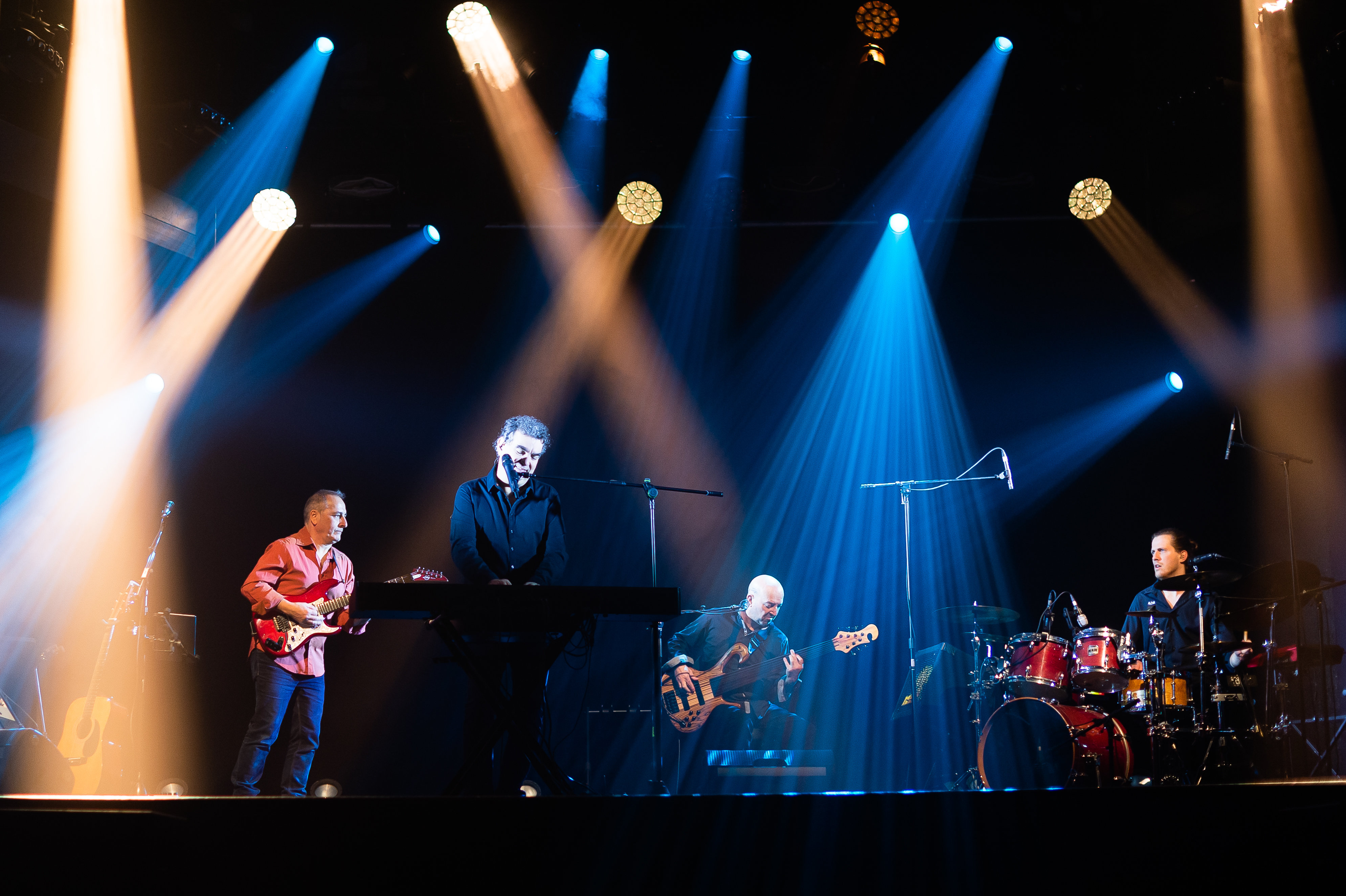 Marc Hévéa en concert avec son groupe lors de la tournée Optimiste Live